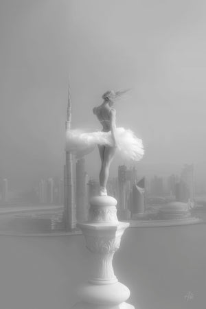 Black and white fine art photograph of a ballerina posed as an ethereal angel, balancing atop a Dubai spire with windswept hair, overlooking the Dubai Water Canal and the city's futuristic skyline, captured with dreamy contrast and soft lighting.