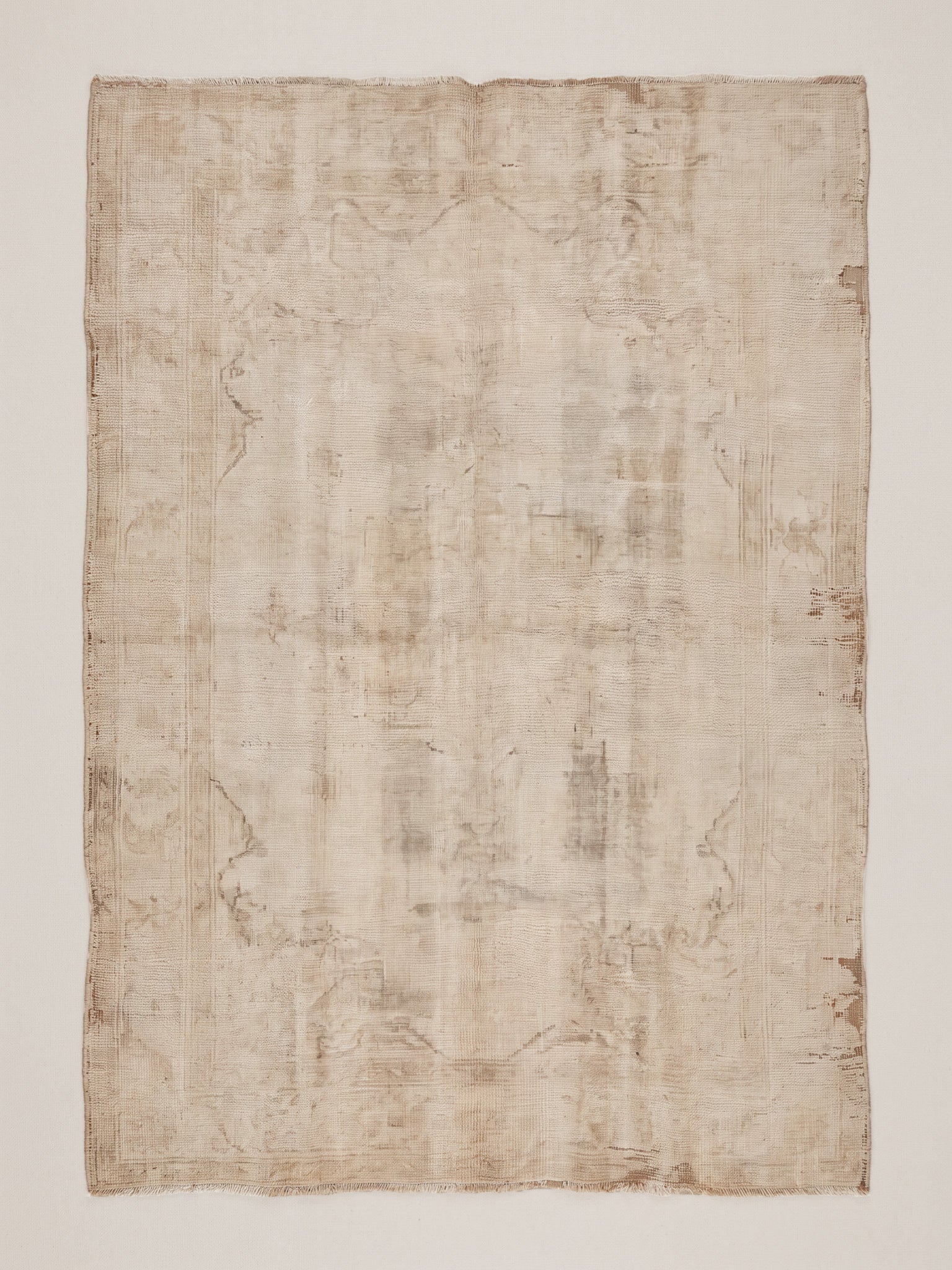 Fine art print of a heavily aged and distressed cream and warm beige flat-woven textile, photographed flat, showing faded medallion motifs, frayed edges, and natural patina consistent with a vintage Turkish or Persian flat-weave rug.