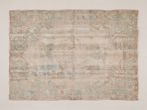 Fine art print of a heavily worn antique Persian or Turkish-style rug featuring a faded medallion and floral arabesque design in soft ivory, pale sage green, dusty rose, and taupe tones, with visible fringe edges and a formal botanical border.