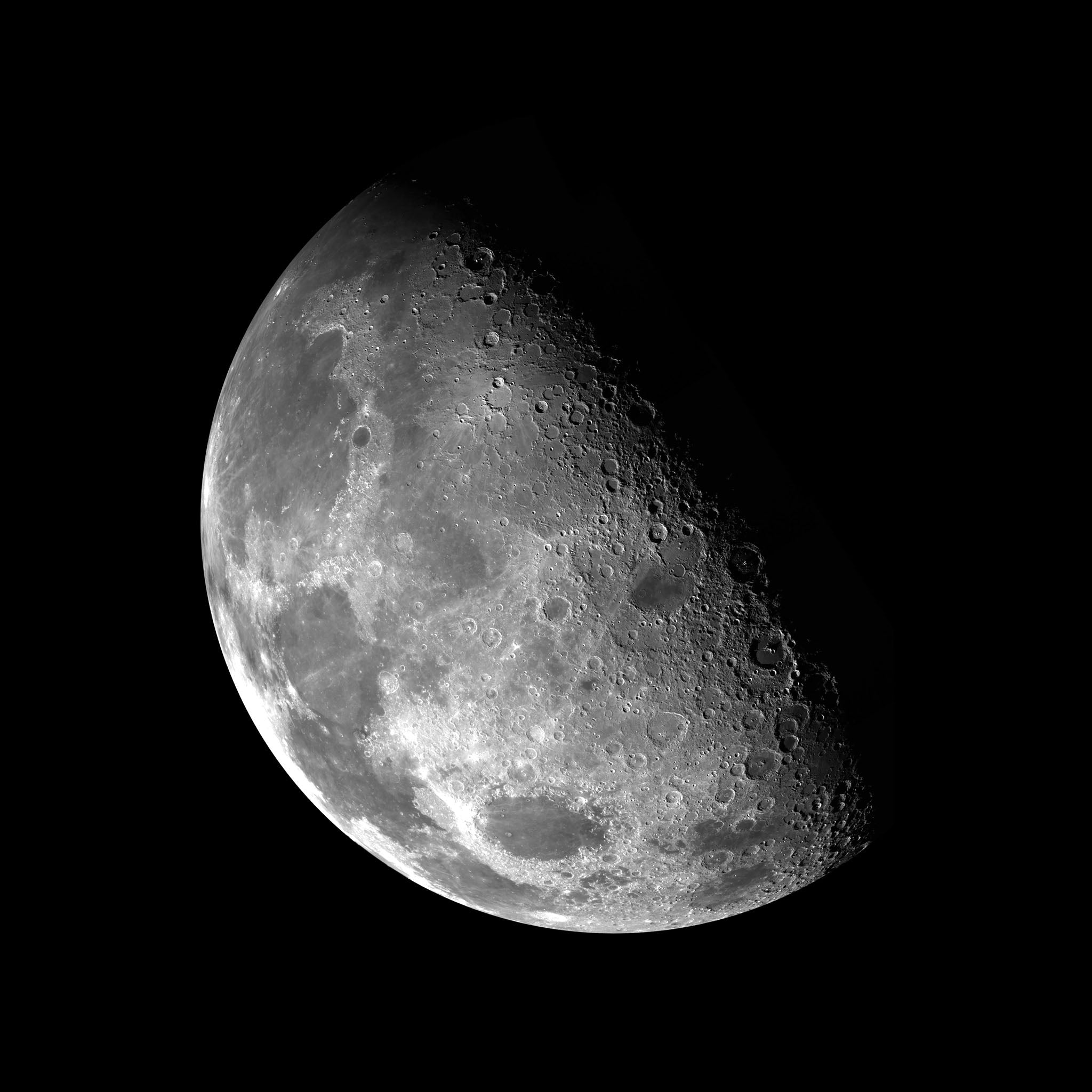 Black and white photograph of the moon in its waxing gibbous phase, showcasing detailed craters and lunar surface textures against a dark, tranquil background.